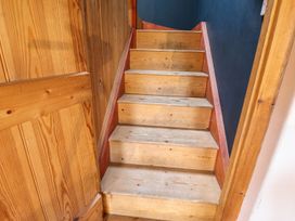 A staircase with wooden steps and a wooden handrail at Llys Gwaun in Fishguard