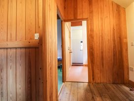 A hallway with wooden walls and doors at Llys Gwaun in Fishguard