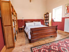 A bedroom with a bed and bookshelves at Llys Gwaun in Fishguard