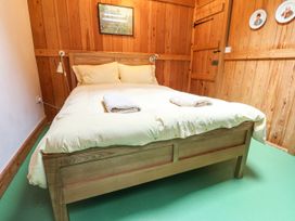 A bedroom with a bed and wooden walls at Llys Gwaun in Fishguard