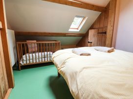 A bedroom with a bed and a crib at Llys Gwaun in Fishguard