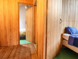 A bedroom with wooden walls and beds at Llys Gwaun in Fishguard
