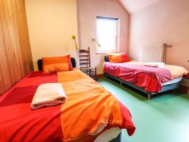 A bedroom with two beds and a chair at Llys Gwaun in Fishguard