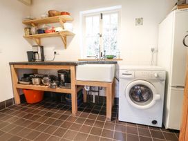 A kitchen with a sink and washing machine at Llys Gwaun in Fishguard
