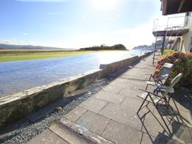 A riverside view with chairs and a pathway at Aldena South Snowdon Wharf Porthmadog