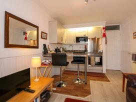 A kitchen with bar stools and appliances at Aldena South Snowdon Wharf Porthmadog