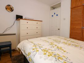 A bedroom with a bed, dresser, and chair at Aldena South Snowdon Wharf, Porthmadog