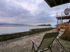 A patio area with chairs and a view of the water at Aldena South Snowdon Wharf Porthmadog