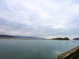 A view of water and mountains with a stone wall at Aldena South Snowdon Wharf in Porthmadog