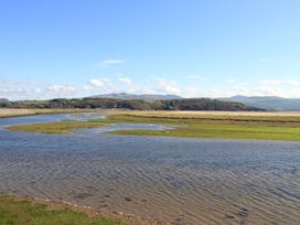 A river winding through grassland with mountains in the background at Aldena South Snowdon Wharf Porthmadog