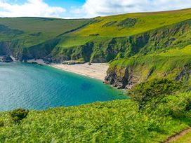 A beach with cliffs and vegetation at 5 Tree Tops in Dobwalls