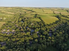 An aerial view of houses and ponds surrounded by trees at 5 Tree Tops in Dobwalls