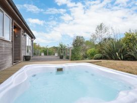 An outdoor area with a hot tub near a wooden deck at 5 Tree Tops in Dobwalls