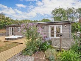 An outdoor area with a hot tub and wooden building at 5 Tree Tops in Dobwalls
