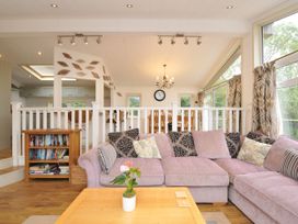 A living room with a sofa and bookshelf at 5 Tree Tops in Dobwalls