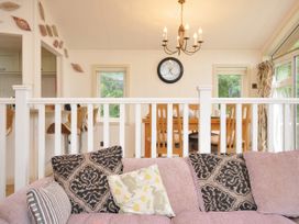 A living room with a sofa and dining area at 5 Tree Tops in Dobwalls