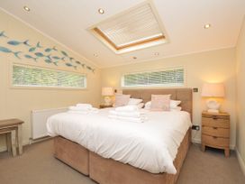 A bedroom with a double bed and fish decoration at 5 Tree Tops in Dobwalls