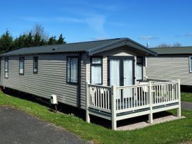 A caravan with a deck in front at Beverley Bay Paignton