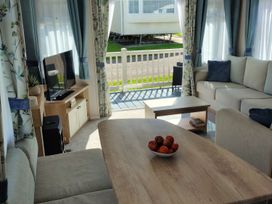 A living room with a sofa and a television at Beverley Bay in Paignton