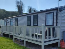 A mobile home with a deck and railing at Beverley Bay in Paignton