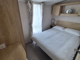 A bedroom with a bed and nightstand at Beverley Bay in Paignton