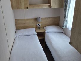 A bedroom with two single beds and a bedside table at Beverley Bay in Paignton