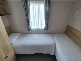 A bedroom with two single beds and a window at Beverley Bay in Paignton