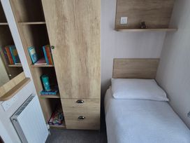 A bedroom with a bed and bookshelves at Beverley Bay in Paignton