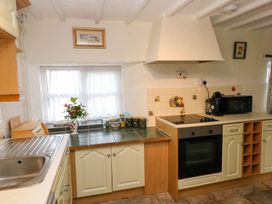 A kitchen with cabinets, counter, sink, and a window at The Stable in Haverfordwest