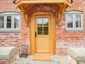 An entrance with a wooden door and windows at Little Red Barn Wallop near Westbury