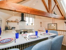 A kitchen with dining area and cooking appliances at Little Red Barn Wallop near Westbury