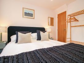 A bedroom with a bed, bedside lamp, and clothes rack at Little Red Barn in Wallop near Westbury