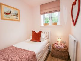 A bedroom with a bed, wall art, and a window at Little Red Barn in Wallop near Westbury