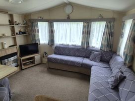 A living room with a sofa and television at Heatherview Willerby in Bishop Auckland