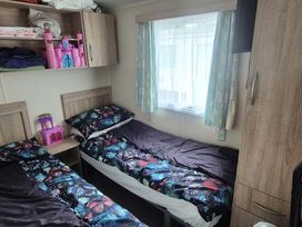 A bedroom with two beds and a pink toy castle at Heatherview Willerby in Bishop Auckland