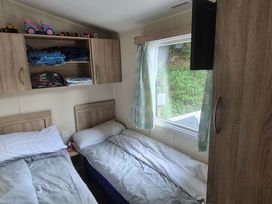 A bedroom with two beds and storage shelves at Heatherview Willerby in Bishop Auckland