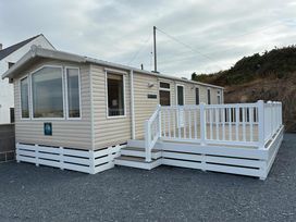 A caravan with white decking and steps at Bwlchgwyn - Bwlchgwyn Caravan, Aberdaron Pwllheli