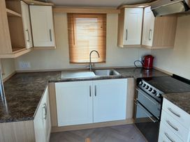 A kitchen with cabinets and a sink at Bwlchgwyn - Bwlchgwyn Caravan, Aberdaron Pwllheli