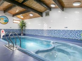 An indoor pool with tiles and a ladder at The Cosy Hedgegrow in Wigton