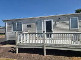 A mobile home with a deck and nameplate at Glendale holiday park in Wigton