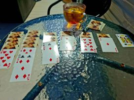 Playing cards laid out on a glass table with a cup of tea at Demelza (B34) Seven Bays Holiday Park Padstow