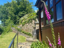 A garden with stairs leading up and a flower at The Old Forge in Bickerton near East Prawle