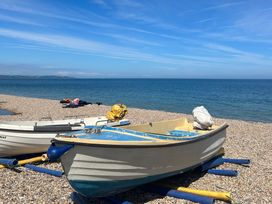 A boat on a pebbled beach near the water at The Old Forge Bickerton near East Prawle