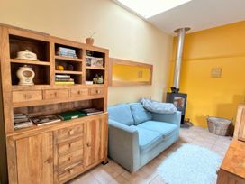 A living room with a sofa and bookshelf at The Old Forge in Hallsands