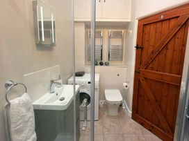 A bathroom with a shower and laundry facilities at The Old Forge in Hallsands