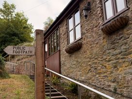 A public footpath sign next to a stone building at The Old Forge in Hallsands