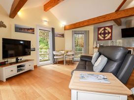 A living room with a television and sofa at Brambleside Lodge in Truro