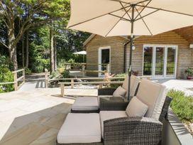 An outdoor seating area with chairs and an umbrella at Brambleside Lodge in Truro
