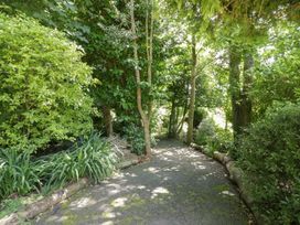 A garden pathway surrounded by trees and plants at Brambleside Lodge in Truro