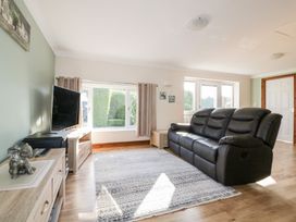 A living room with a black sofa and television at Lower Brambleside in Truro